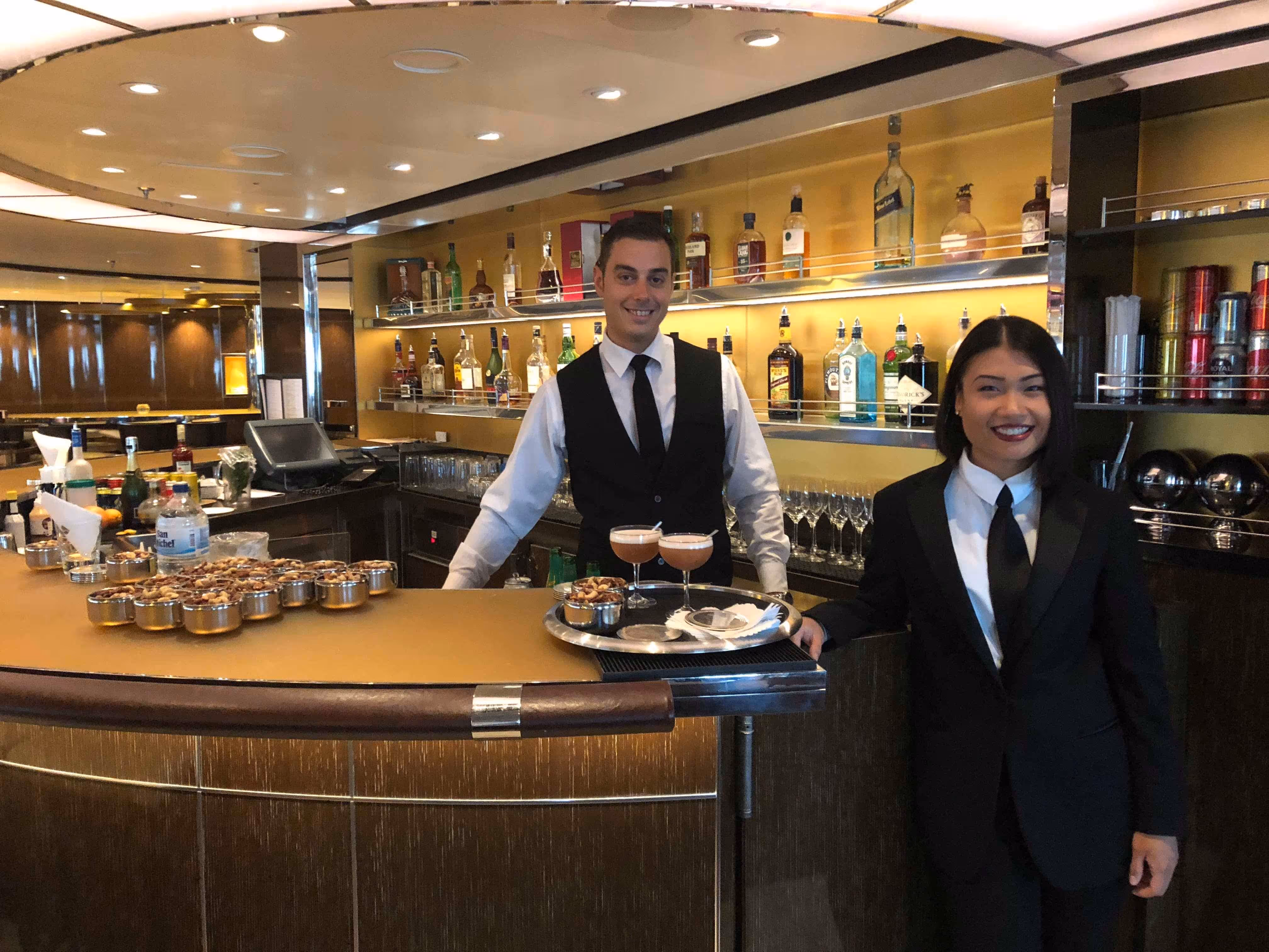A man and a woman standing in front of a bar.