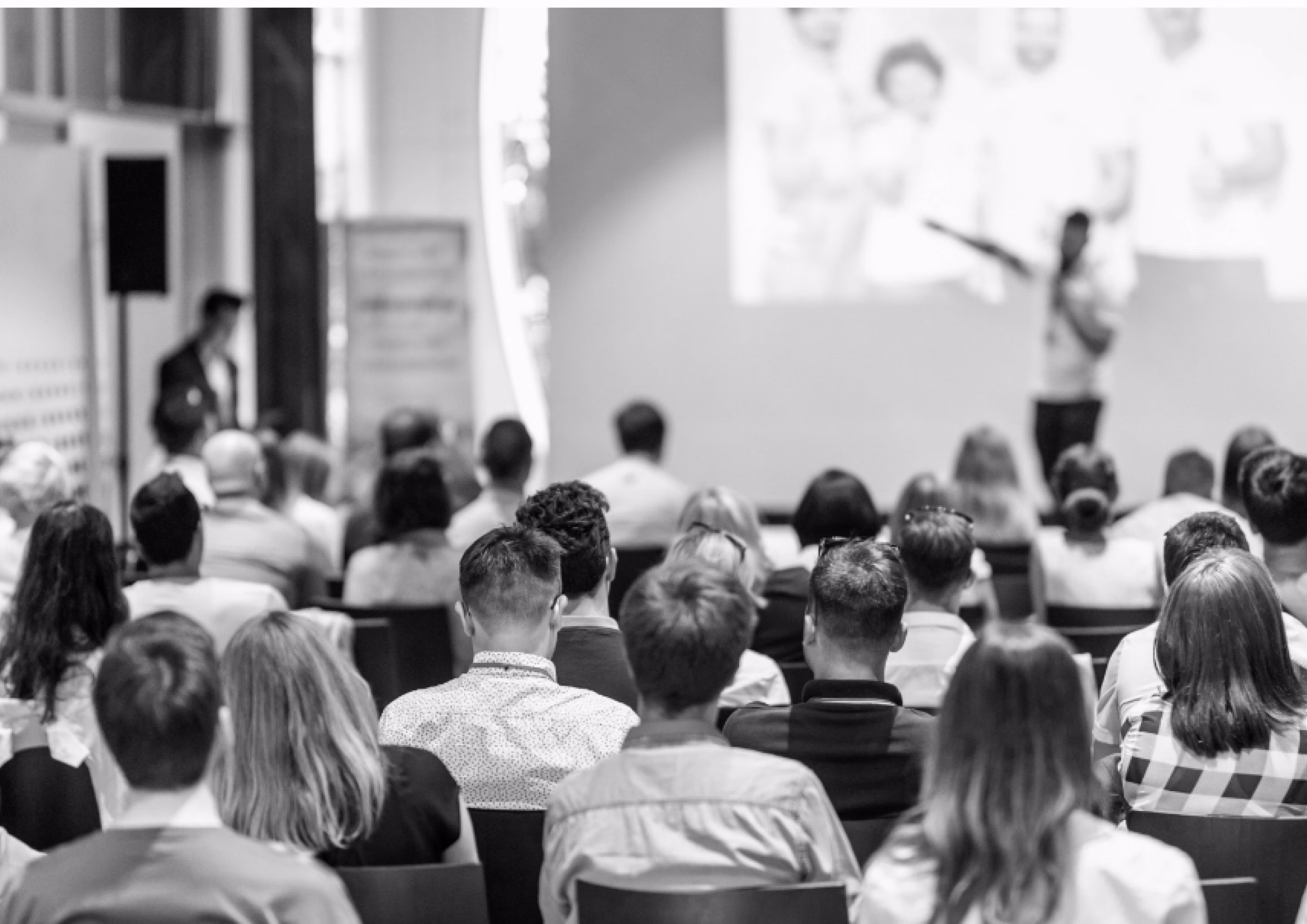 Attendees listening to a speaker during a healthcare conference presentation.