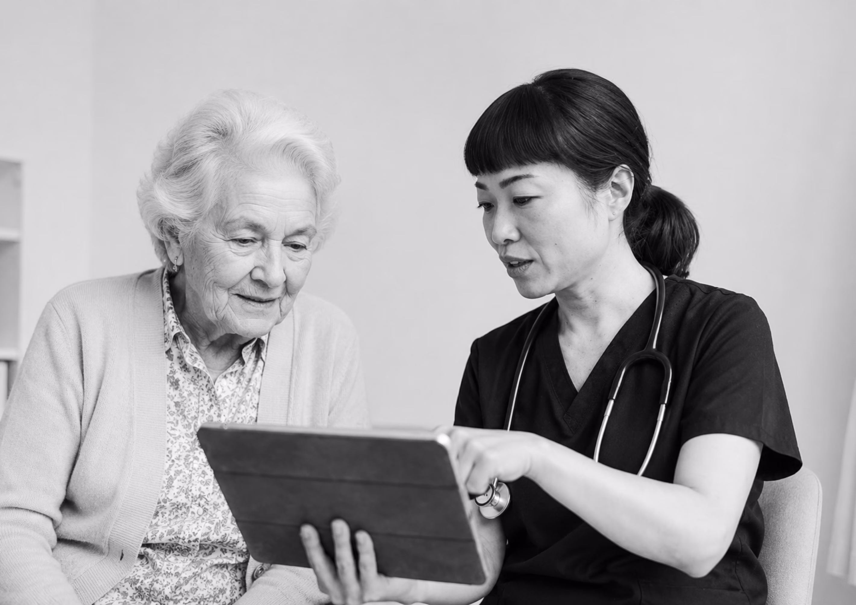 Healthcare professional showing information on a tablet to an older patient.