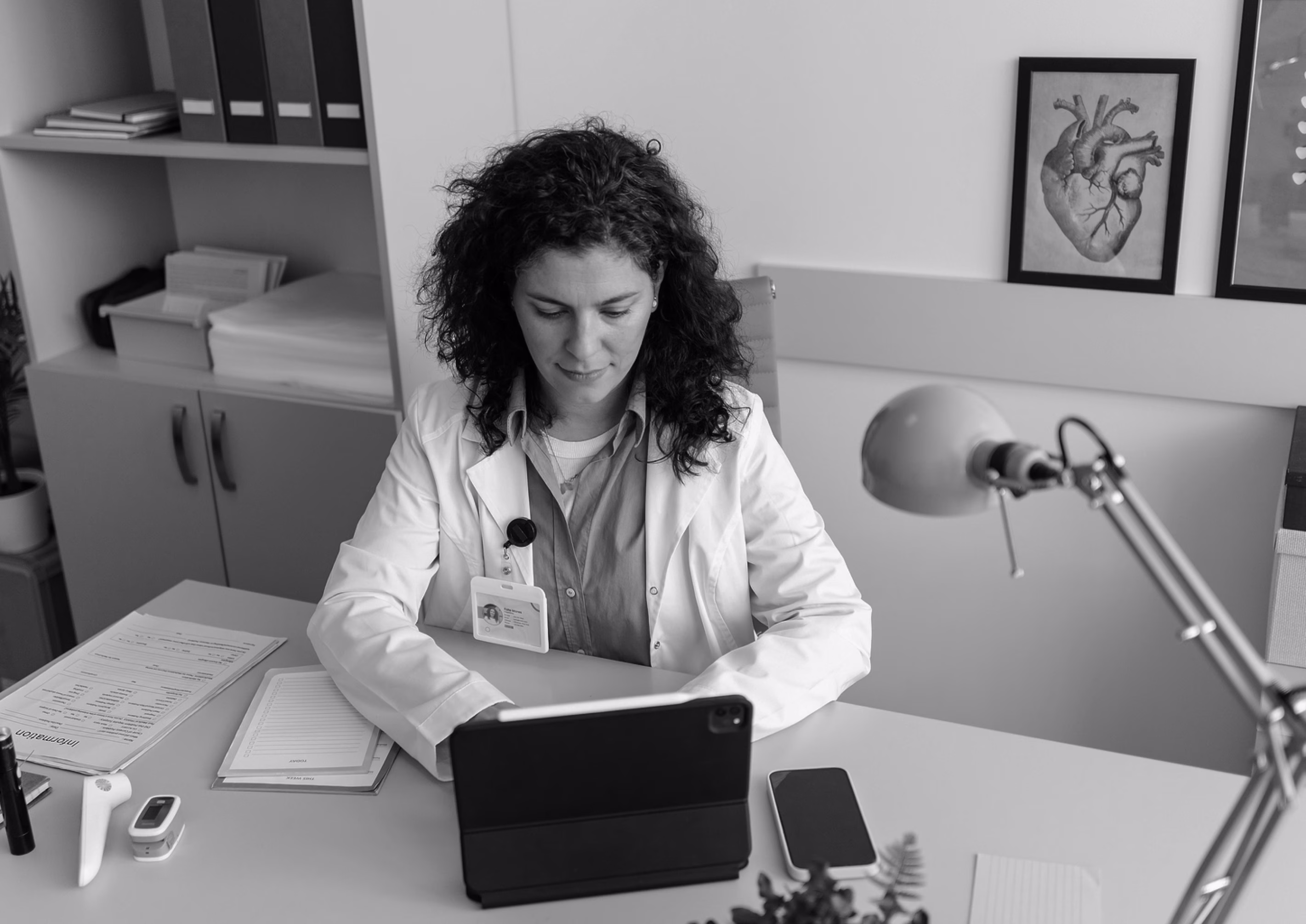 Physician reviewing information on a tablet at her desk.