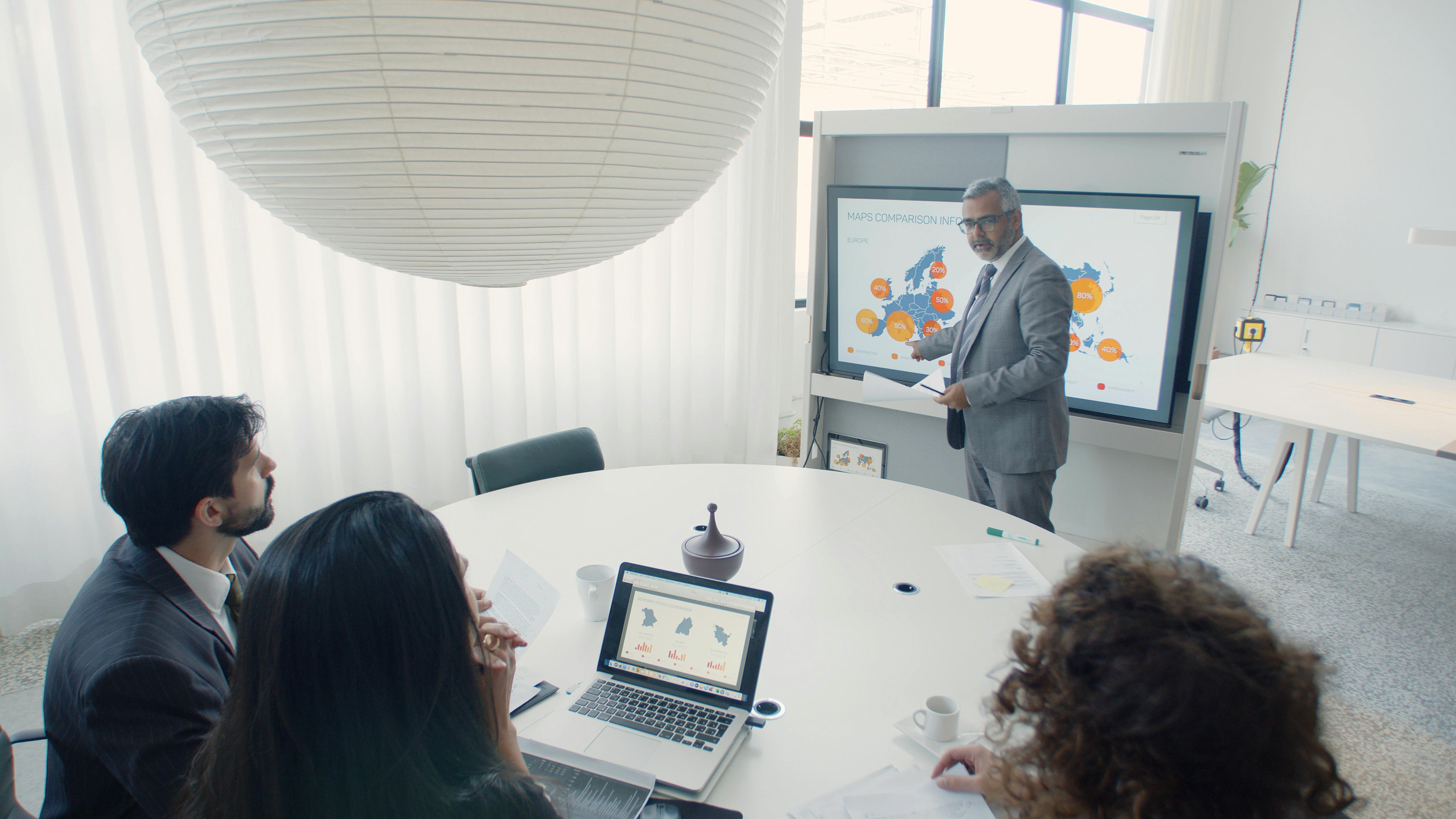 A man presenting to a team round a table.