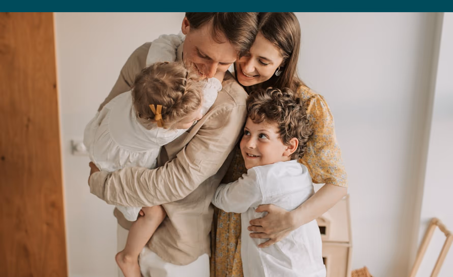 Loving family hugging together, parents holding two children warmly