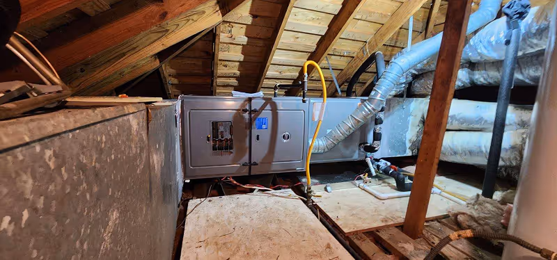 HVAC system and electrical panel installed in wooden attic space