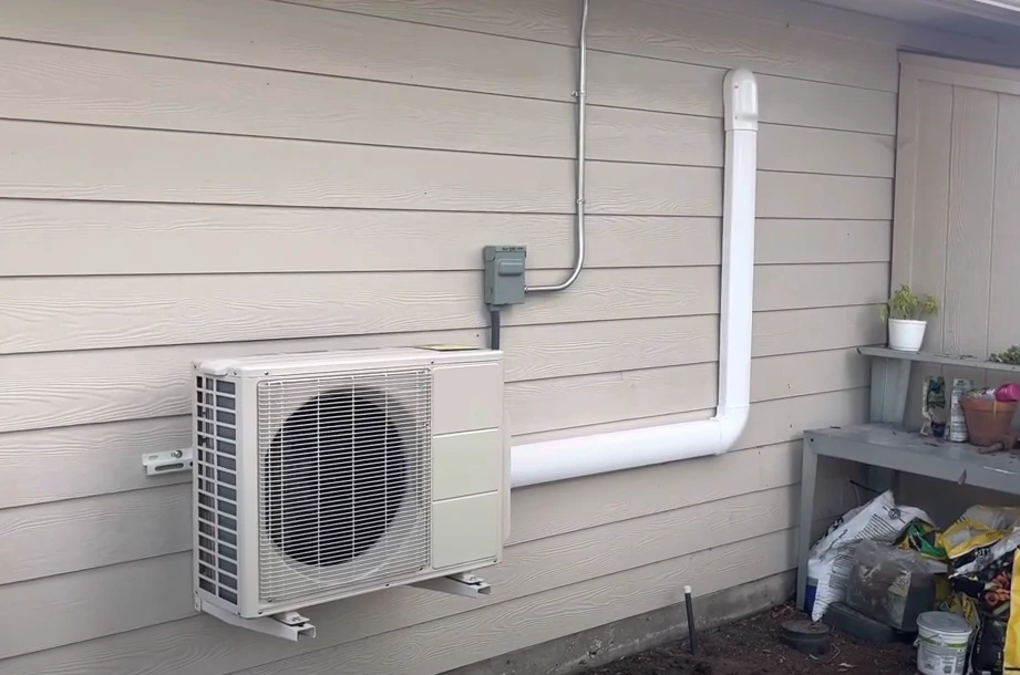 White ductless mini-split air conditioner mounted on exterior house wall