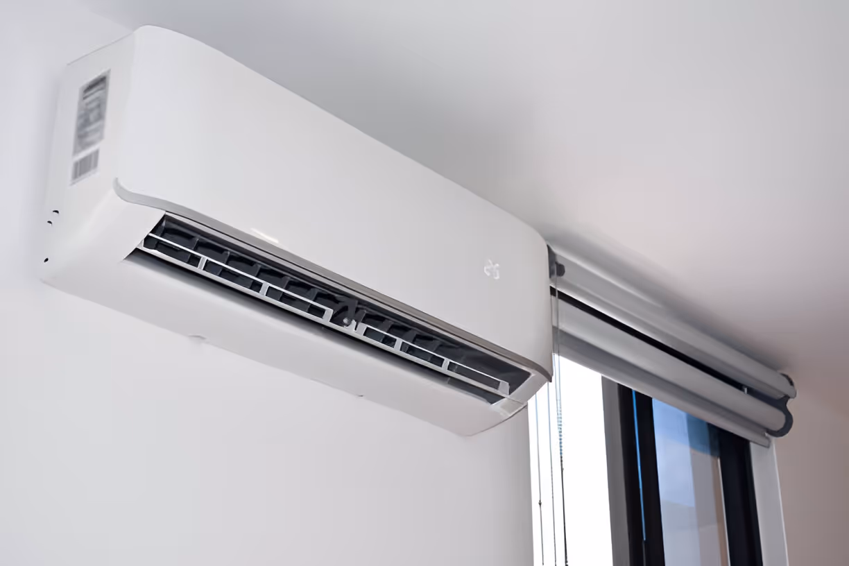 White mini-split air conditioner mounted on wall near window