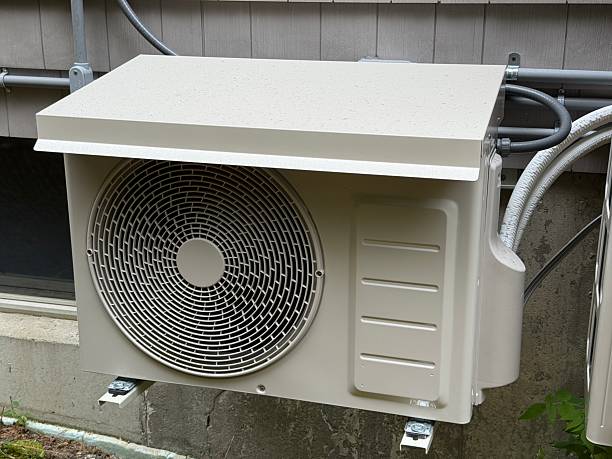 White air conditioning outdoor unit mounted on concrete wall