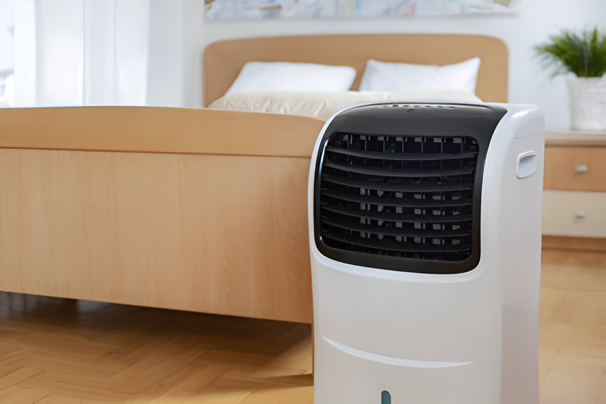 Portable air conditioner in bedroom next to wooden bed and nightstand