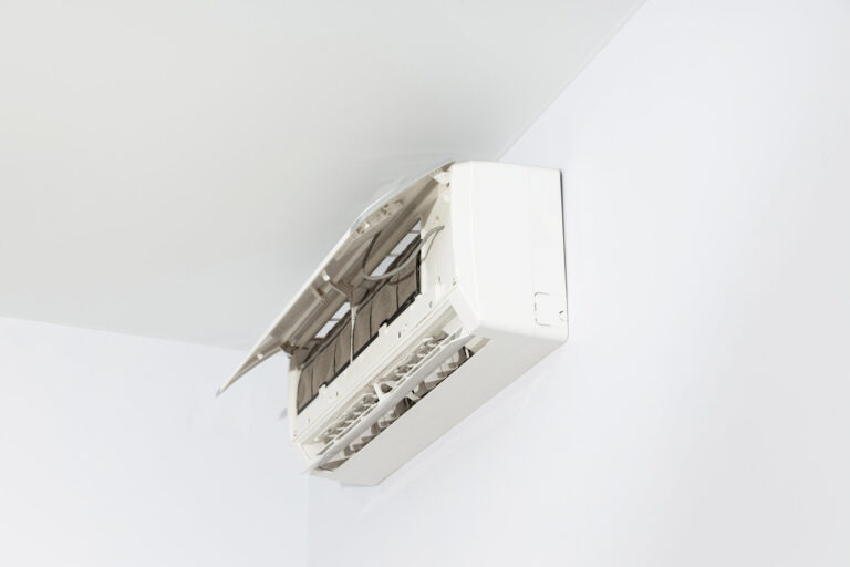 A clean, wall-mounted ductless mini-split air conditioner is shown with its front panel open, revealing the filter and internal components.