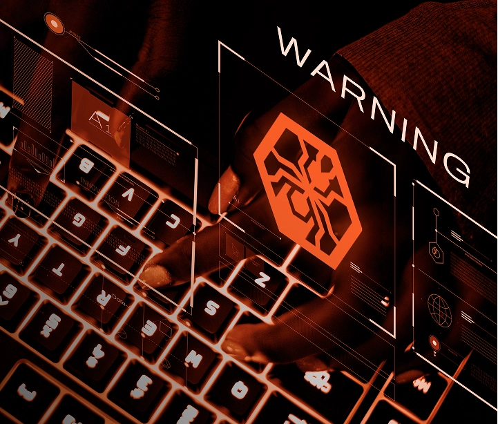 Glowing keyboard with cyber threat warning symbol.