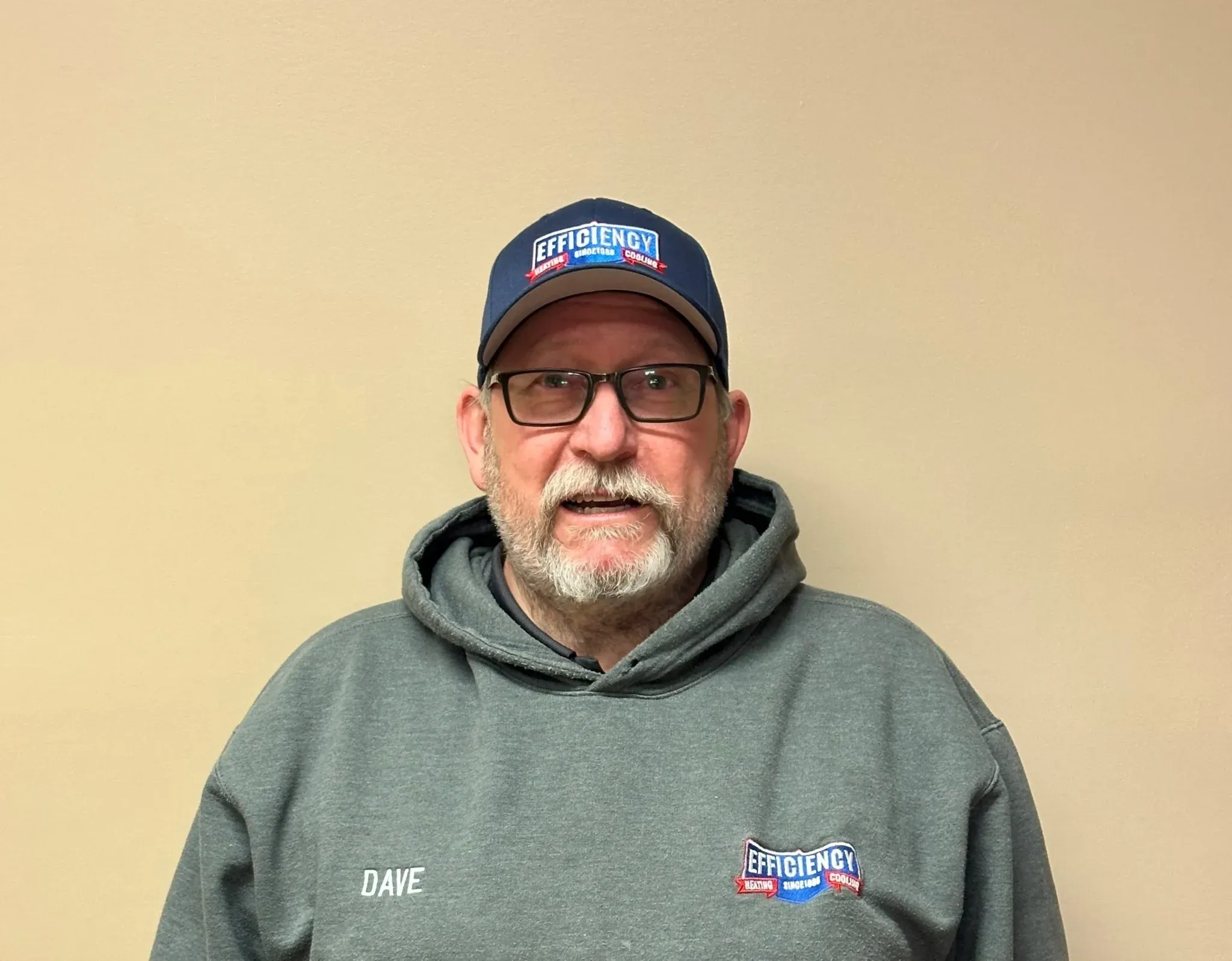 Middle-aged man in Efficiency company hoodie and cap, smiling
