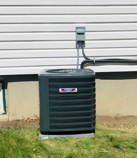 Green air conditioning unit installed outside a house with white siding