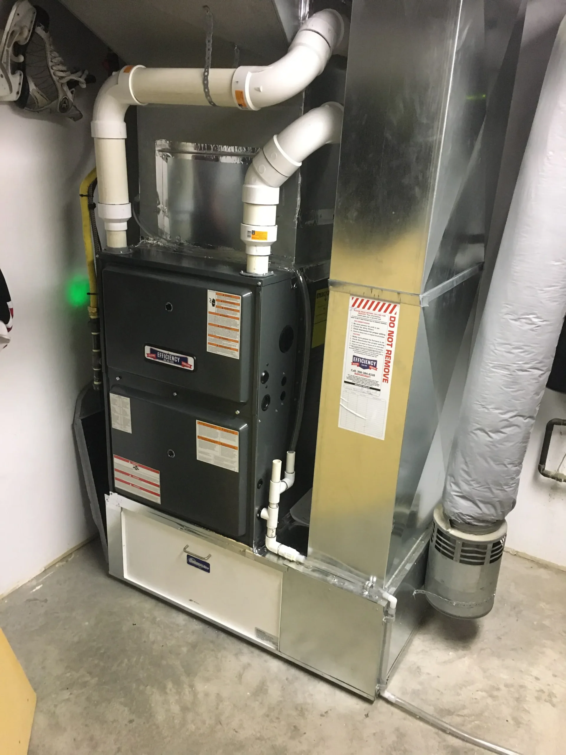 Efficiency furnace with white PVC pipes in a mechanical room