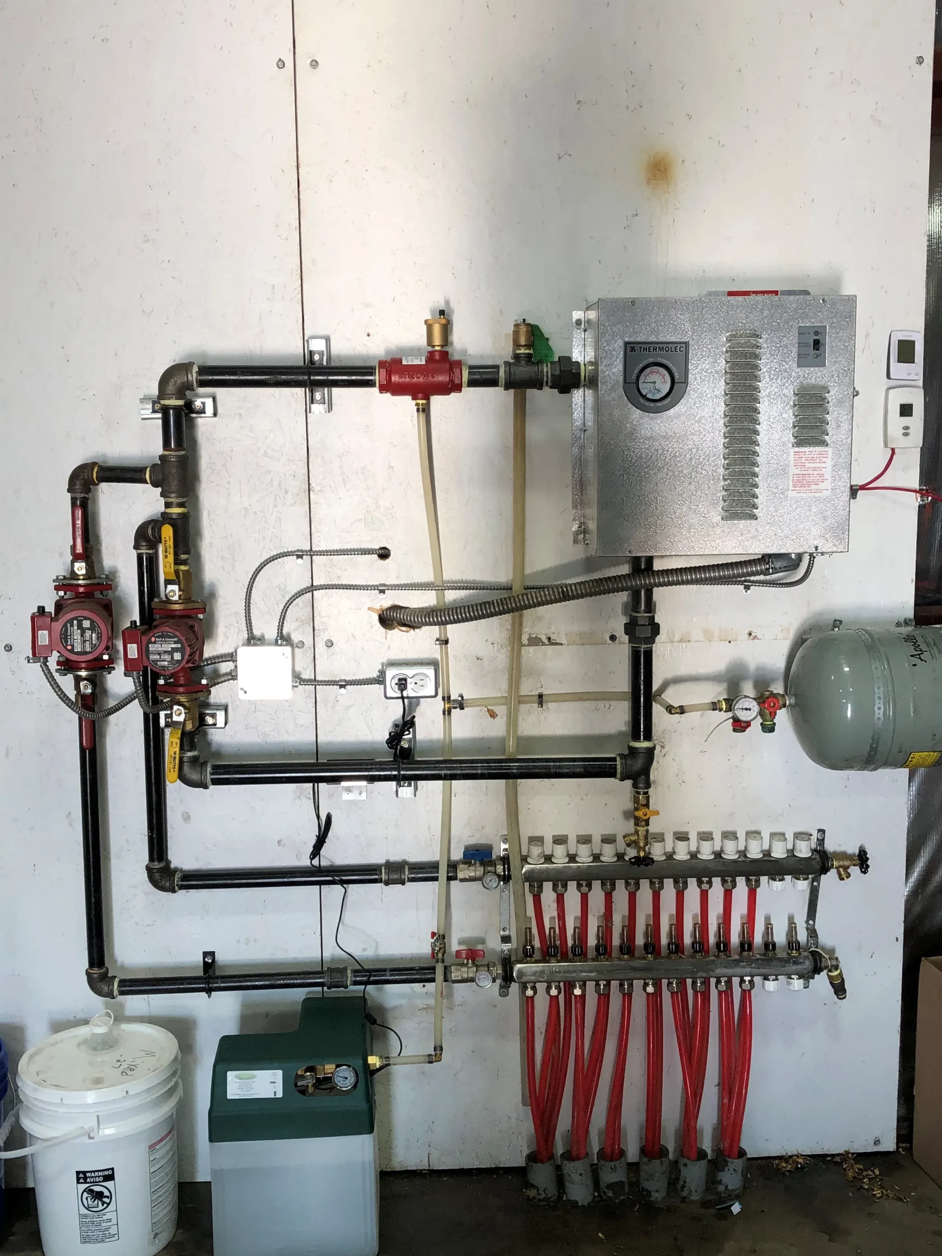 Heating system with pipes, valves, control box, and red distribution manifold