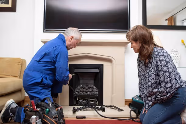 Technician and homeowner inspect fireplace during home maintenance service