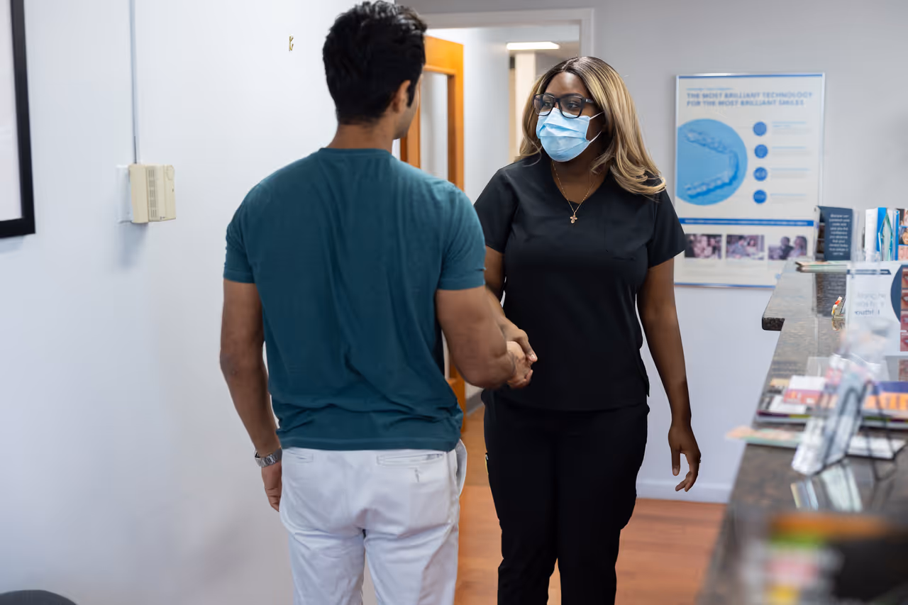 Dental staff member greeting a patient at a dental office.