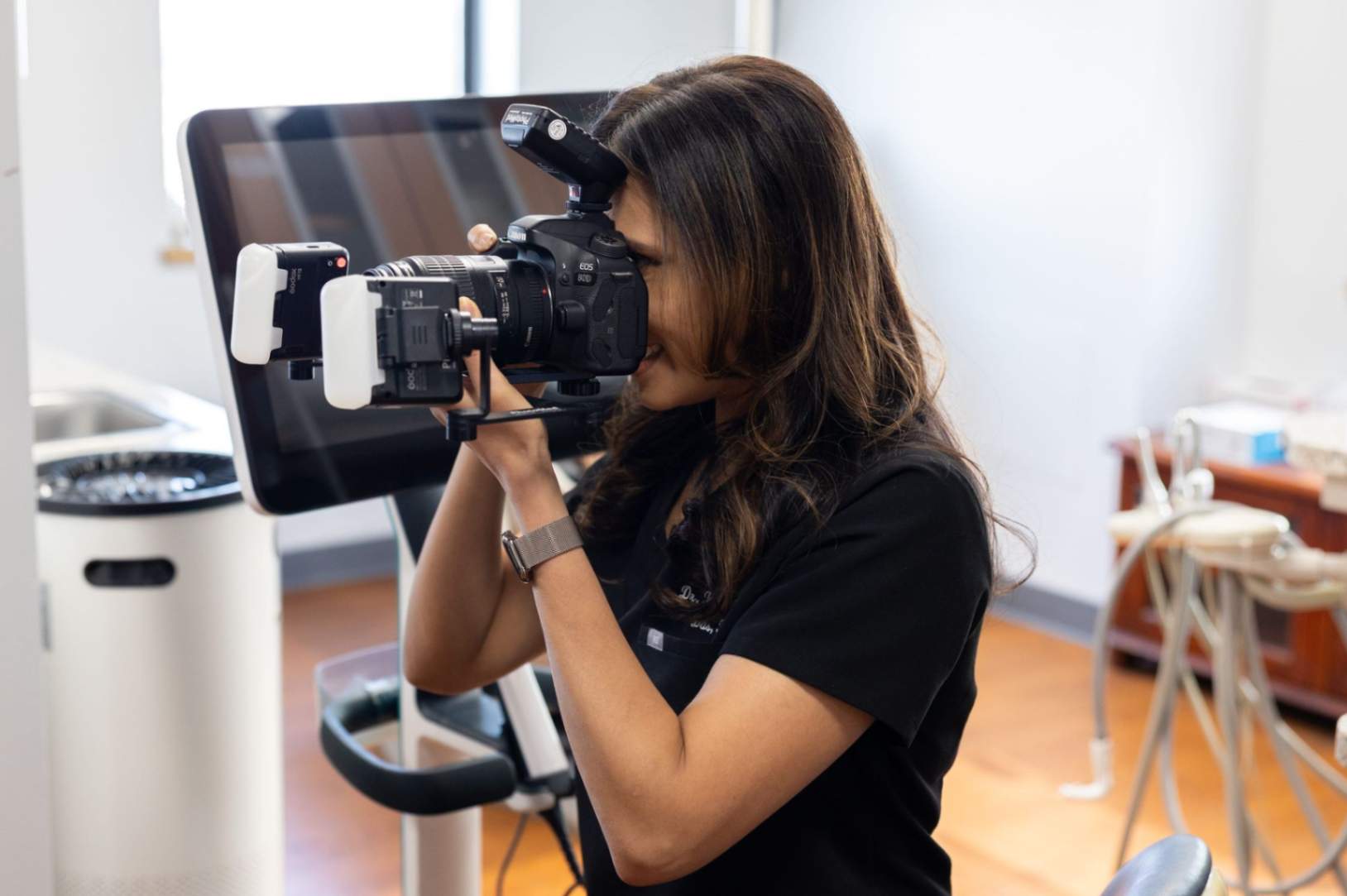 Dentist taking an intraoral photograph of a patient's teeth using a dental camera.
