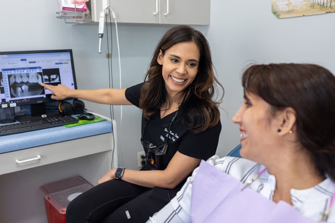 Kirti Chopra, DDS explaining dental X-rays to a patient during a consultation.
