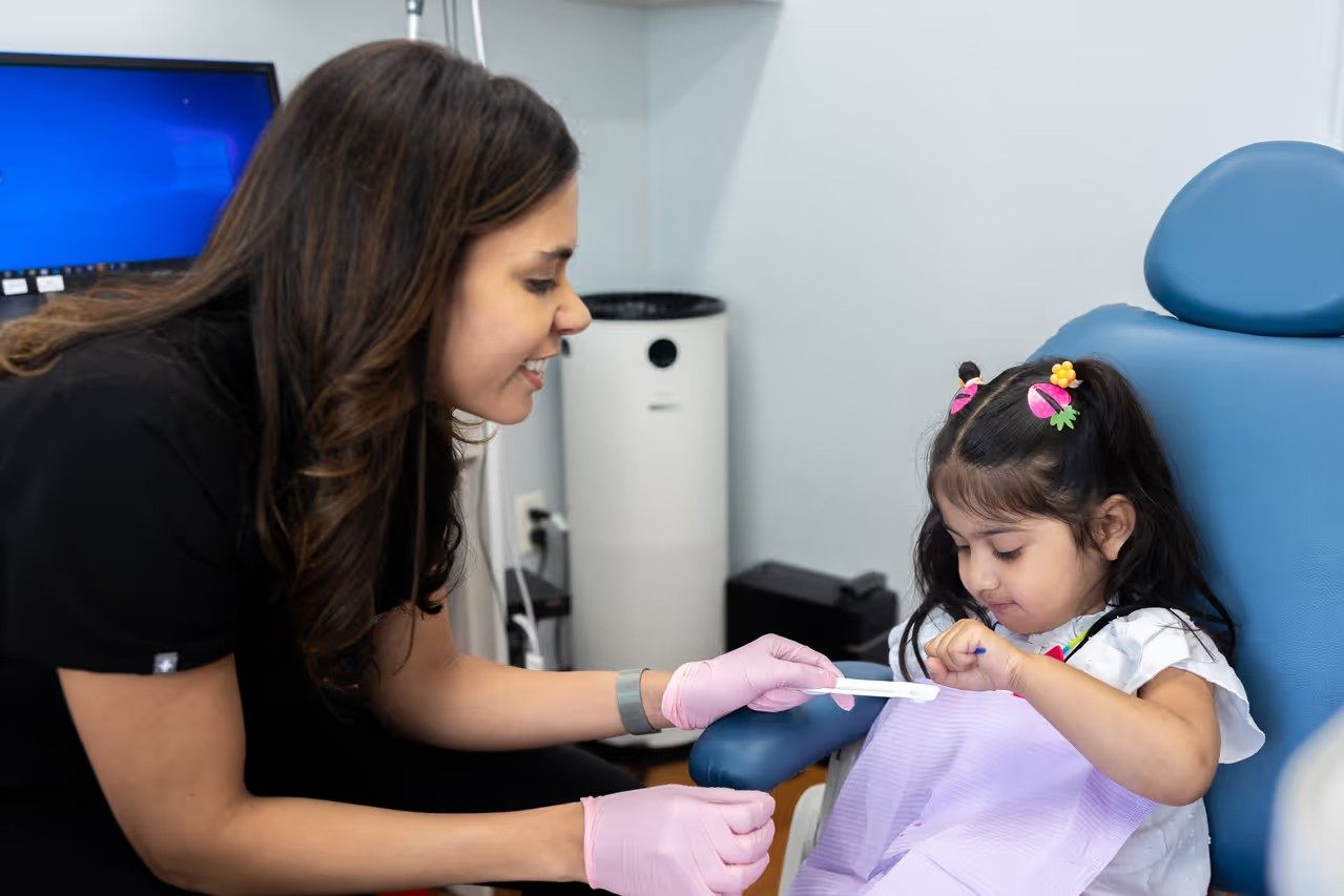 Kirti Chopra, DDS interacting with a young child during a dental visit.