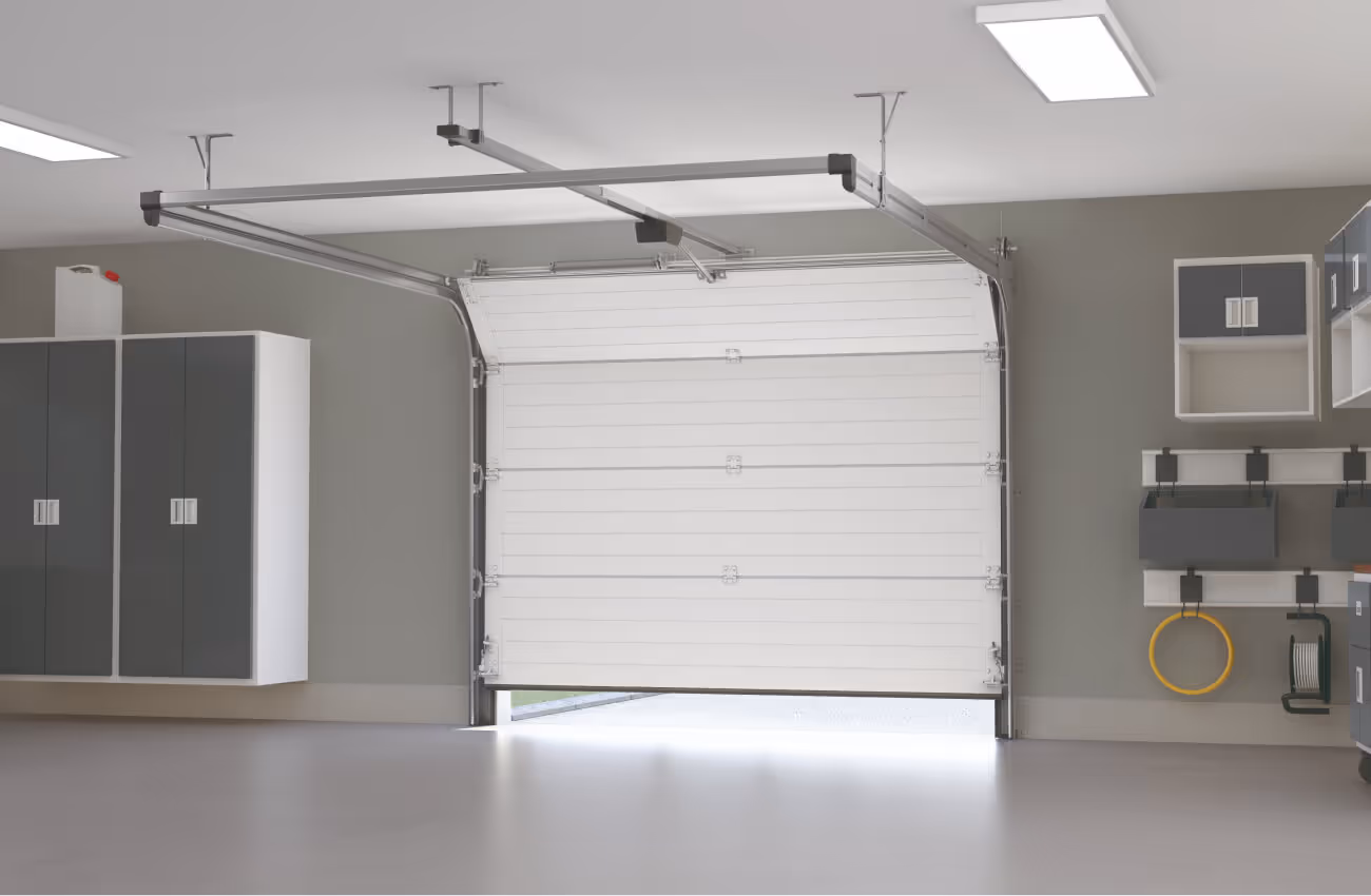 Installation d'une grande porte de garage blanche motorisé par Morel Services dans l'Ain (01)