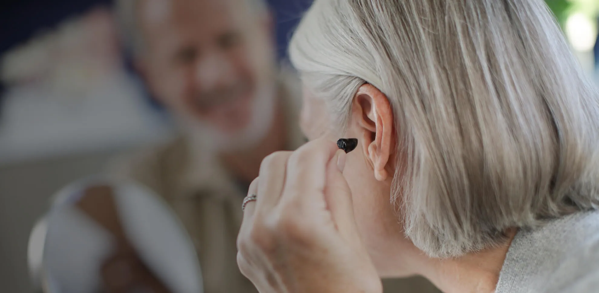 Woman with blonde hair inserting small hearing aid into ear.RetryClaude can make mistakes. Please double-check responses.