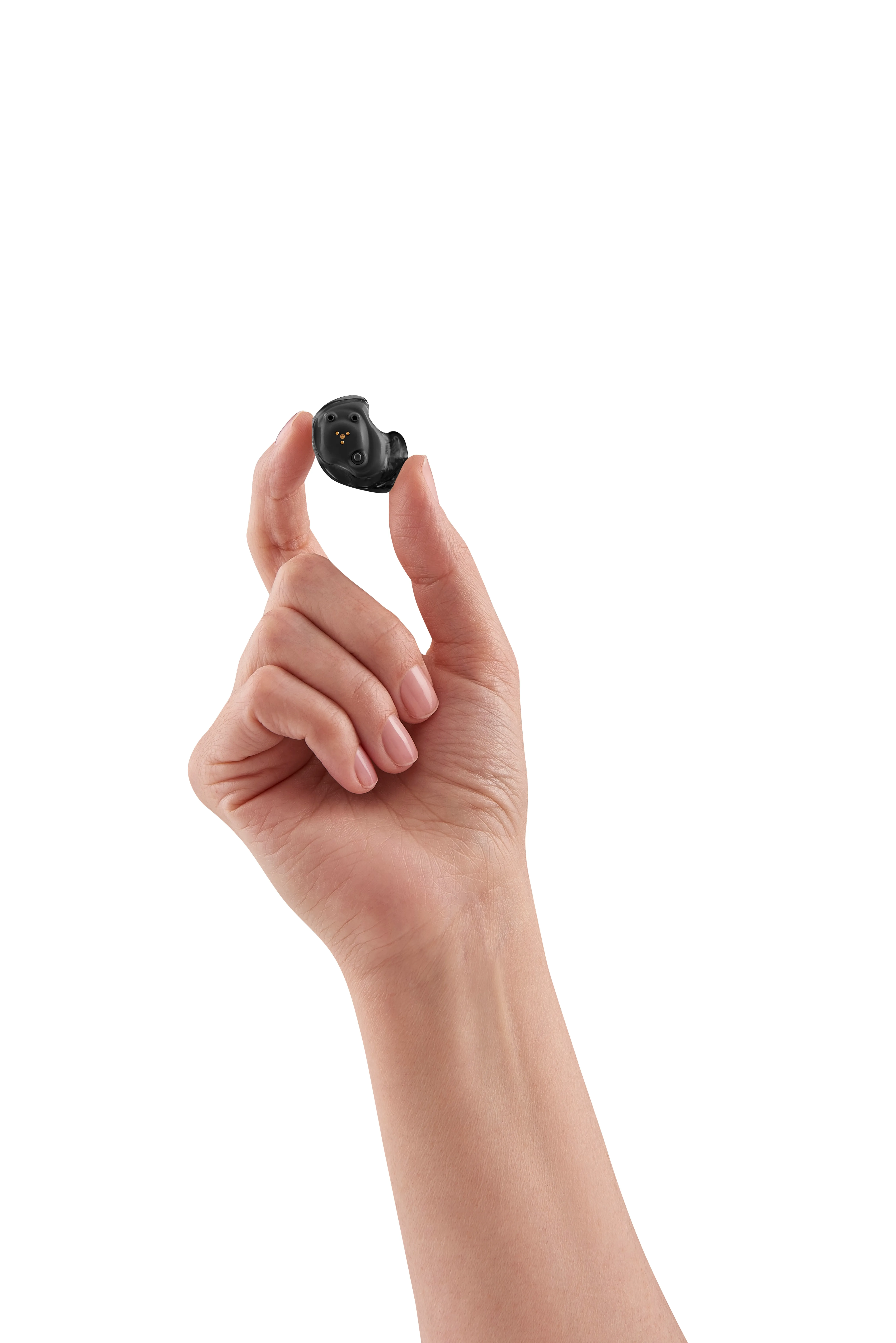 Hand holding small black hearing aid against white background.