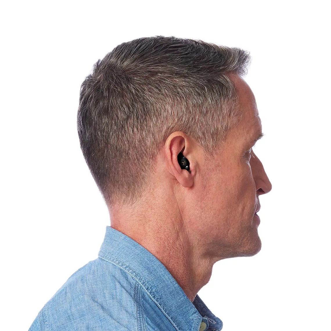 Side profile of man with short grey hair wearing discreet in-ear hearing aid.