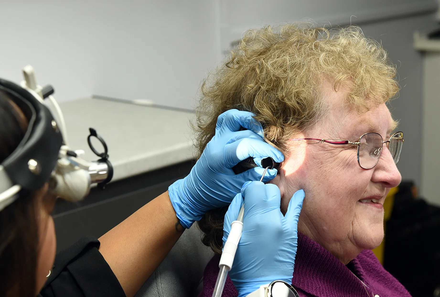 Clinician removing ear wax from a patient's ear using microsuction