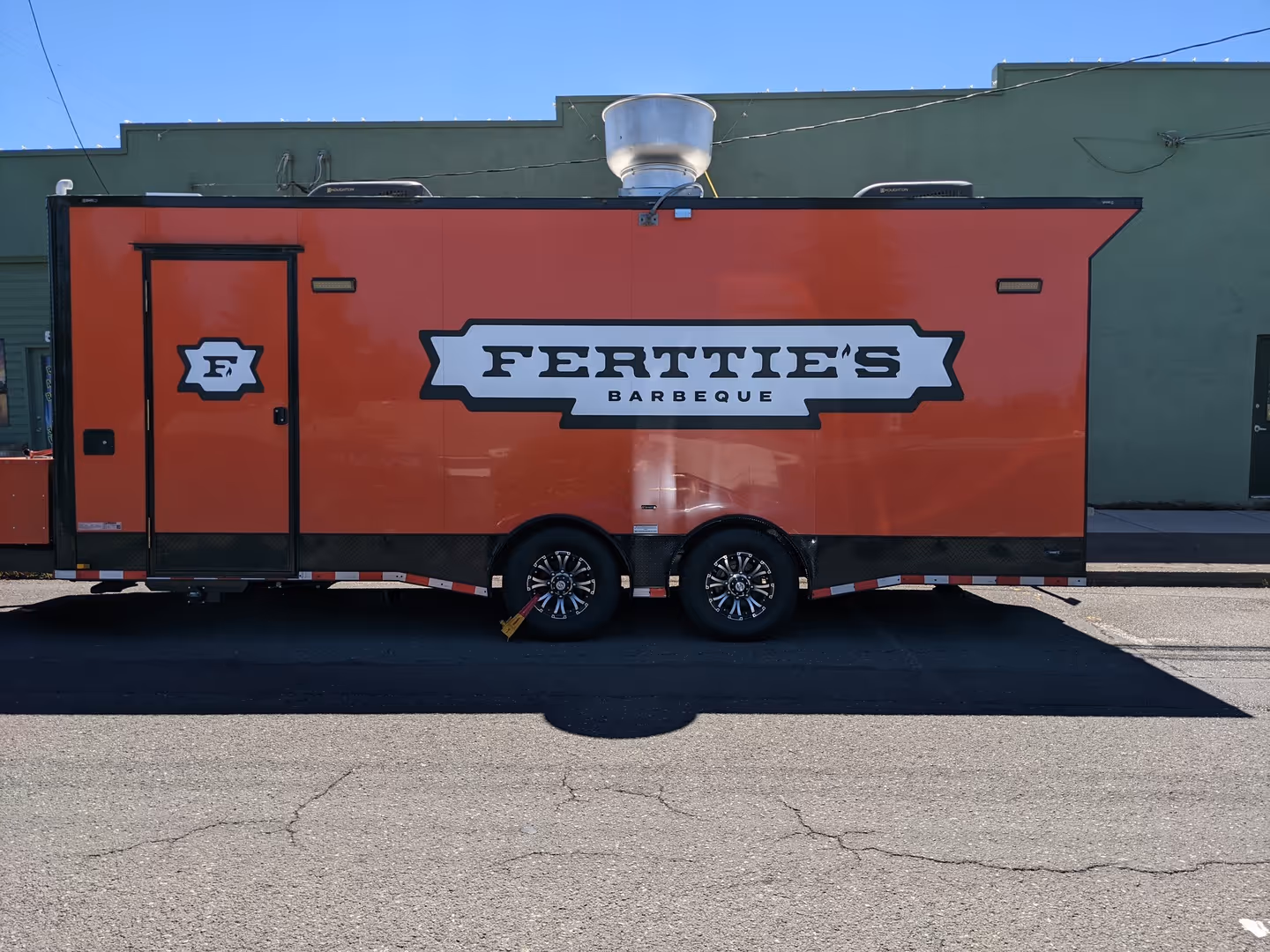 A red trailer parked in front of a building.