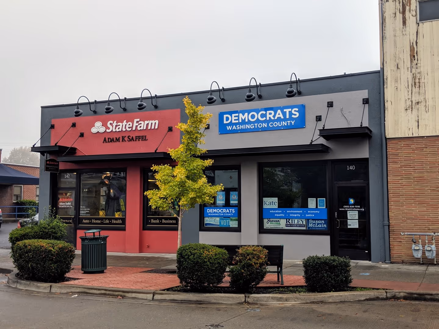 A store front with a tree in front of it.