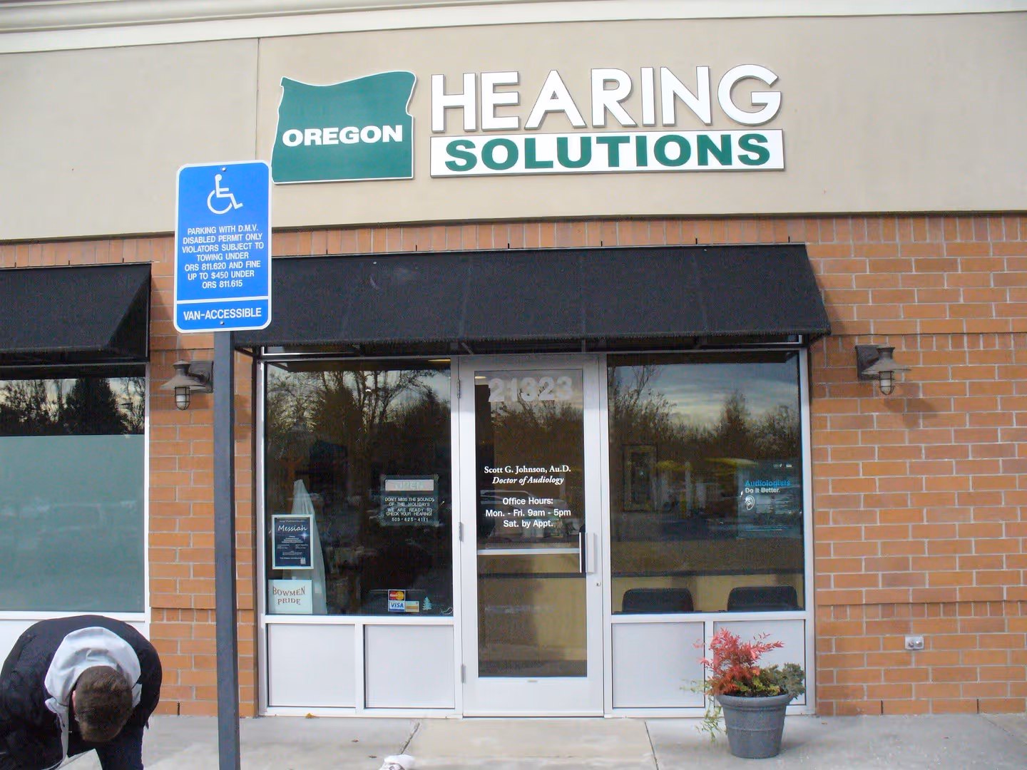 A person bending over in front of a building.