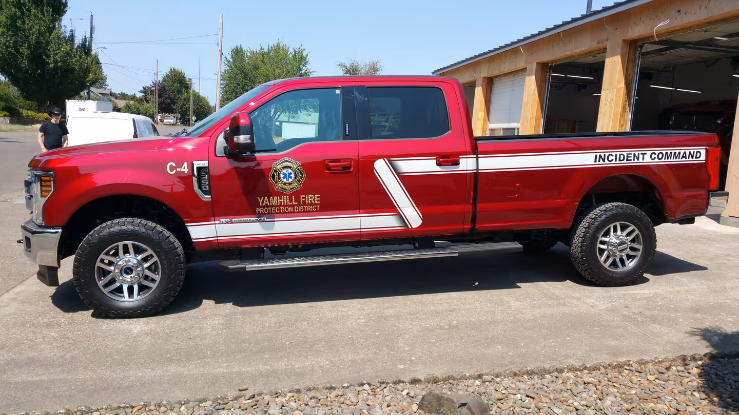 A red truck parked in front of a building.