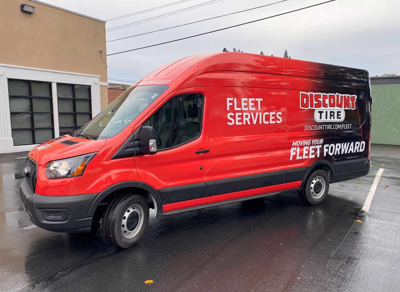A red van parked in a parking lot.