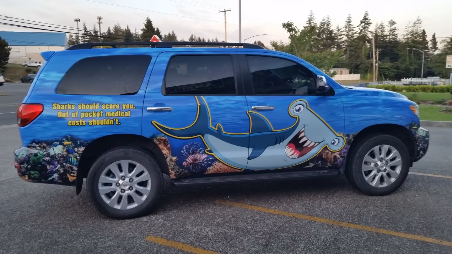 A blue suv with a shark painted on it.