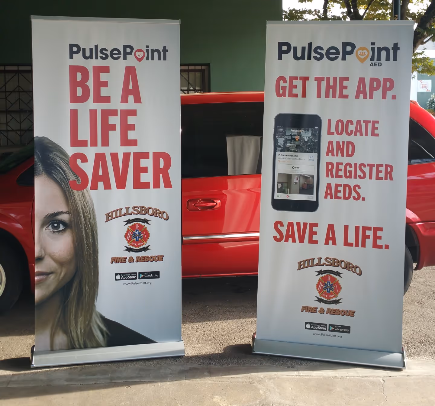 A red car parked in front of a bus stop.