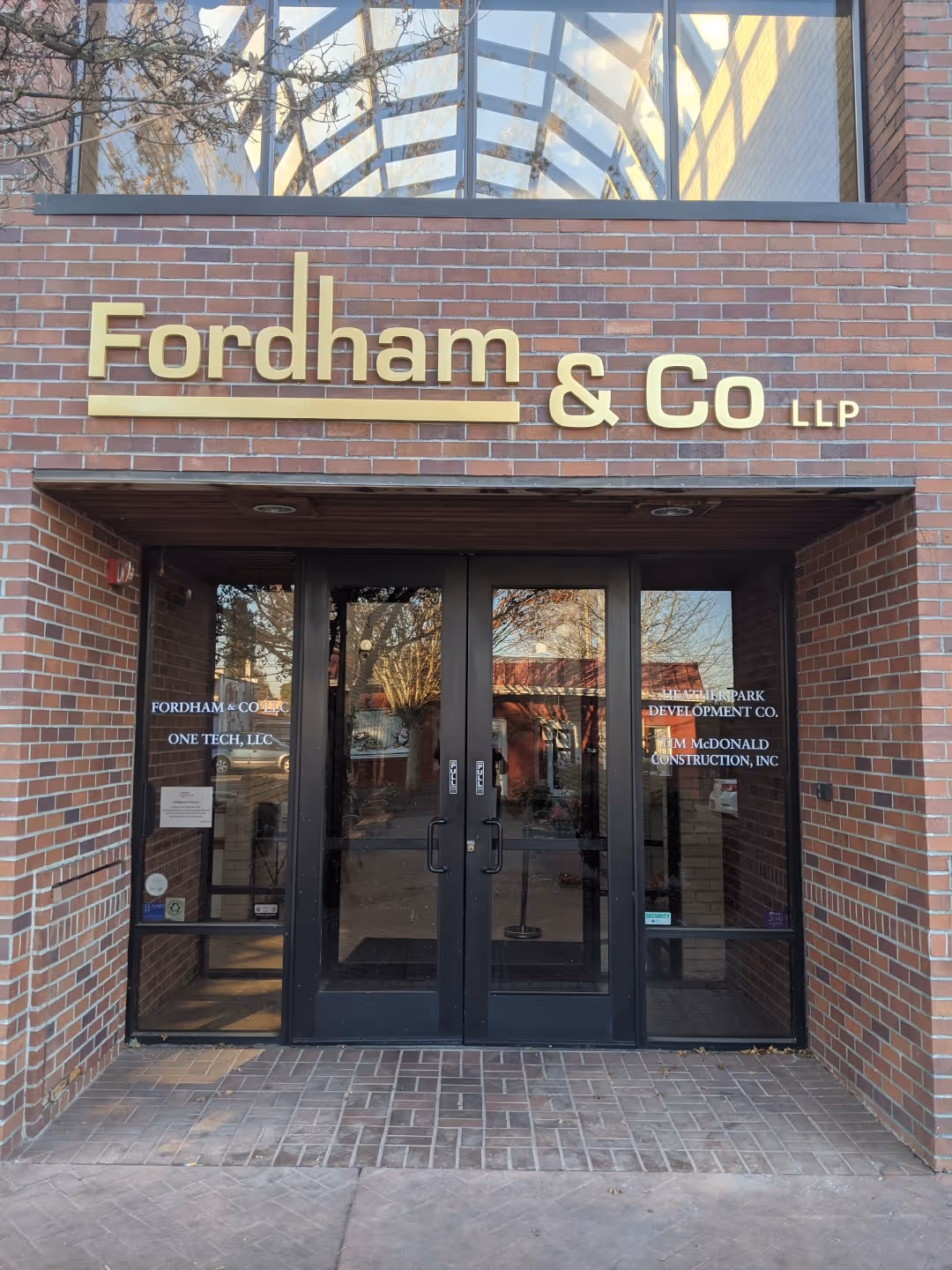 A brick building with two doors and a sign on the front of it.