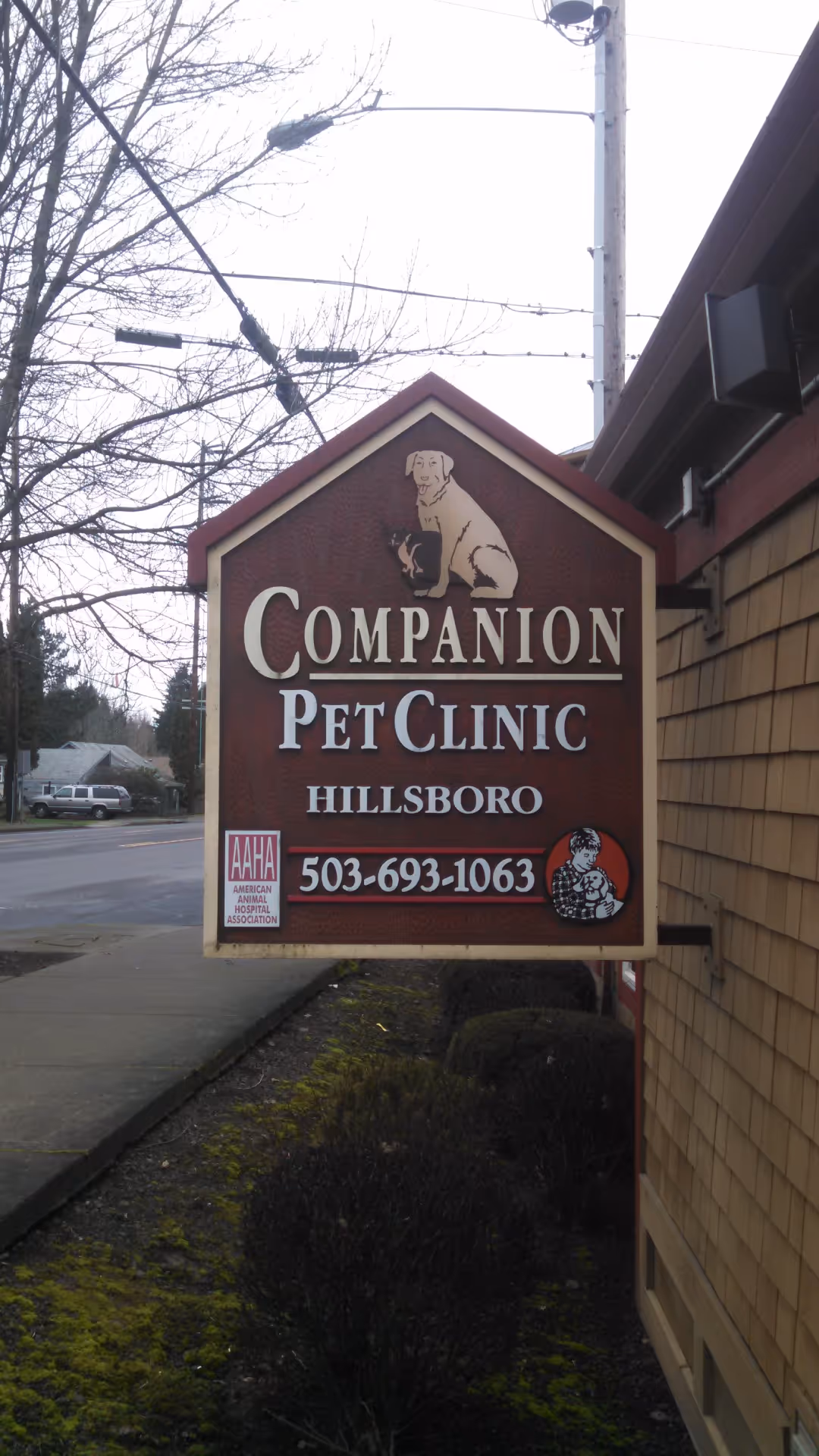 A sign for a pet clinic with a dog on it.