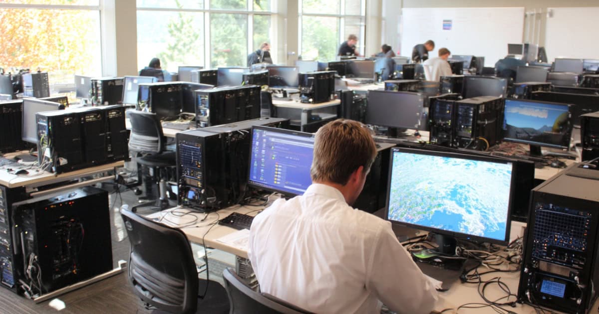 A group of Managed IT services specialist setting up computers in a classroom