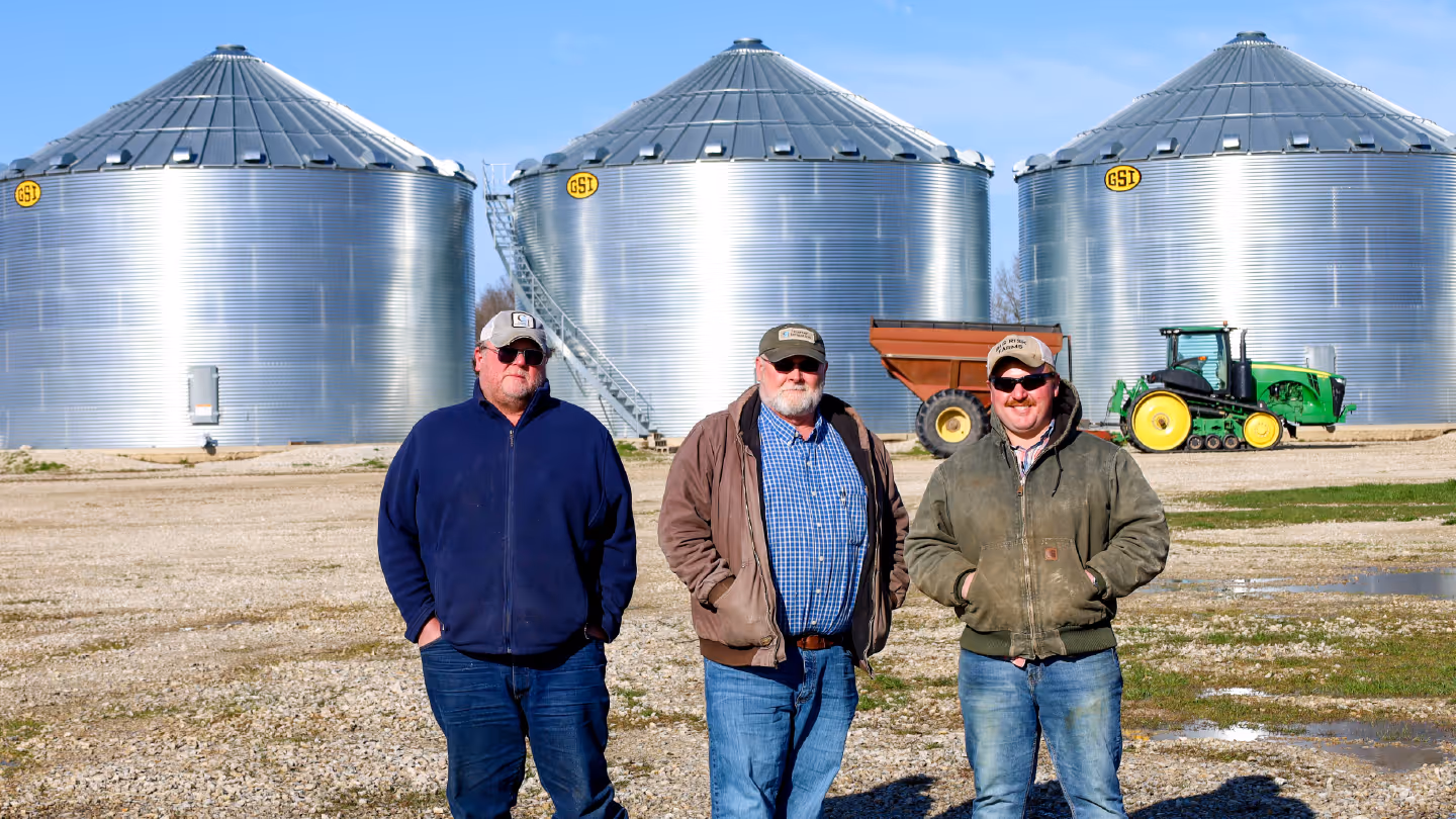 The Booths standing in front of a grain silos.