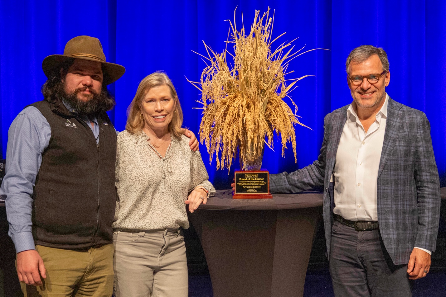 A group of people standing next to a trophy Description automatically generated