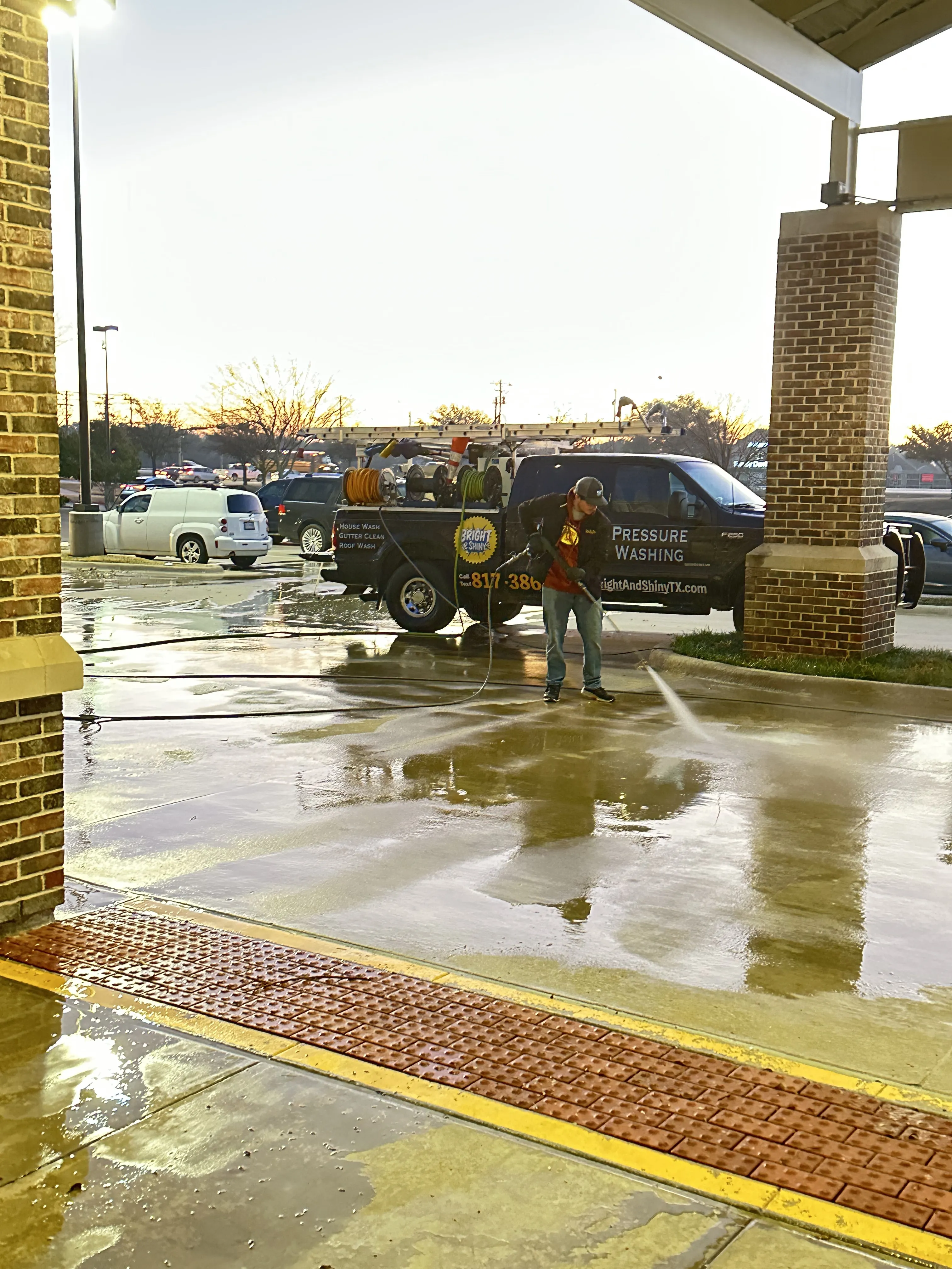 Bright & Shiny technician pressure washing a commercial concrete entrance