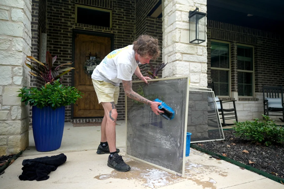 Technician cleaning a residential window screen
