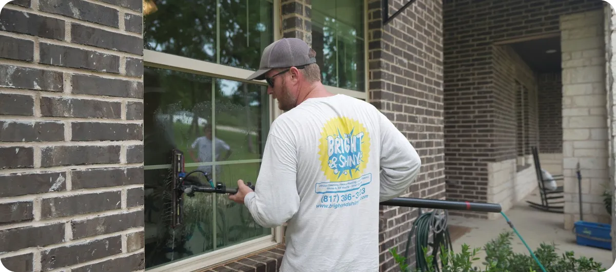 Bright & Shiny technician cleaning a residential exterior window