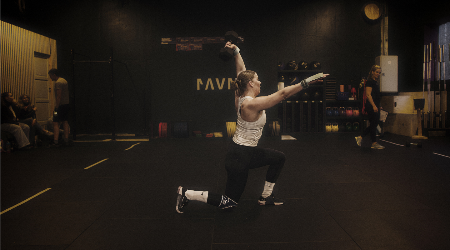 A man and woman perform kettlebell exercises in a gym at CrossFit Ravn Fitness, showcasing HWPO accessories.