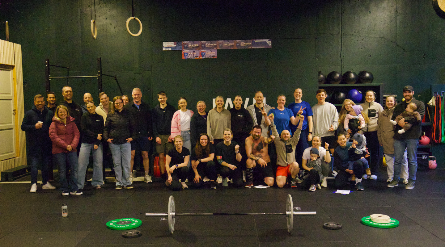 A man and woman exercising together at CrossFit Ravn Fitness in Førresfjorden, RO, showcasing teamwork and fitness.