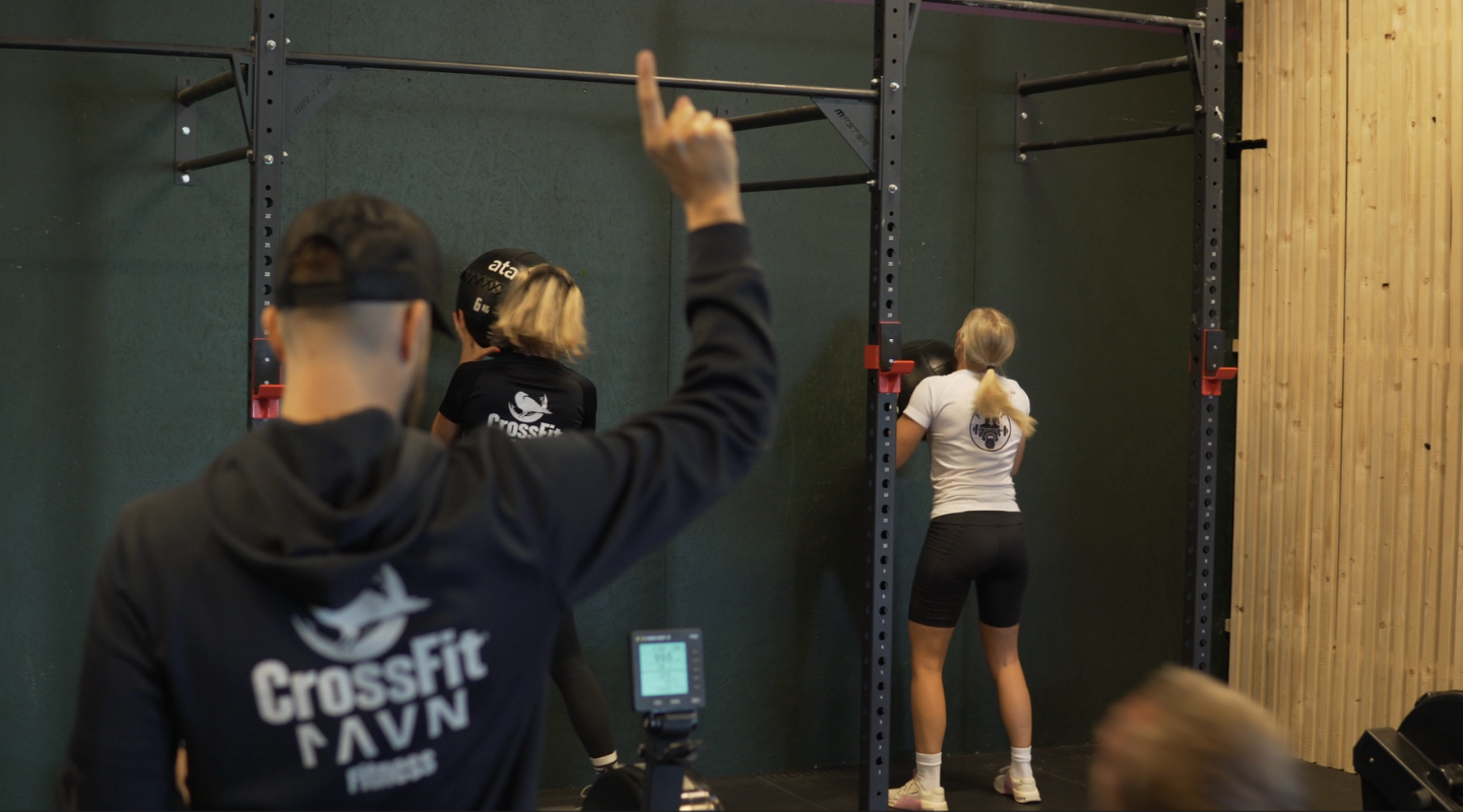 A group of people exercising in a gym, with one individual using a rowing machine at CrossFit Ravn Fitness in Førresfjorden, RO.