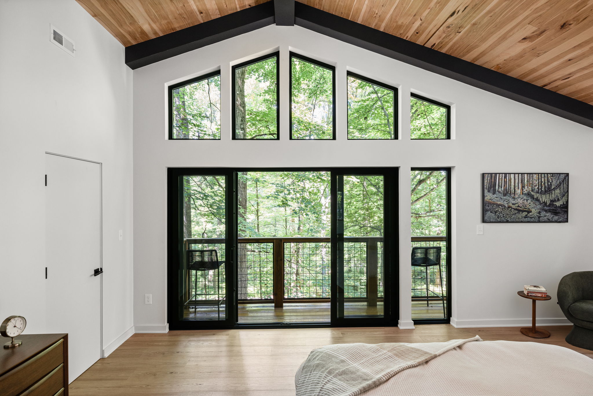 Vaulted ceiling bedroom with double doors to balcony – Custom home addition designed by Emergent Construction with seamless indoor-outdoor flow.