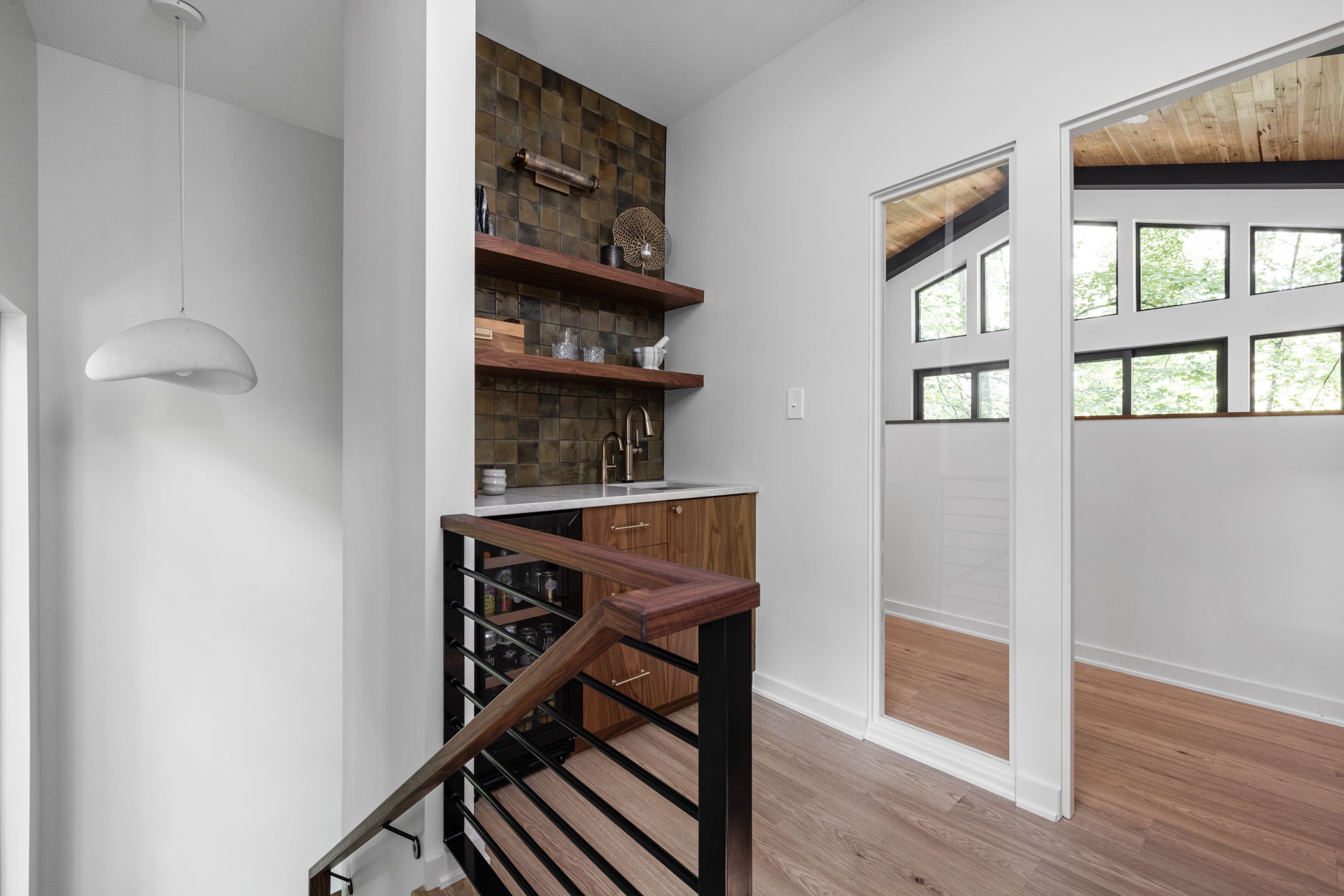 Upstairs hallway with built-in wood shelving – Custom carpentry and modern design details by Emergent Construction.