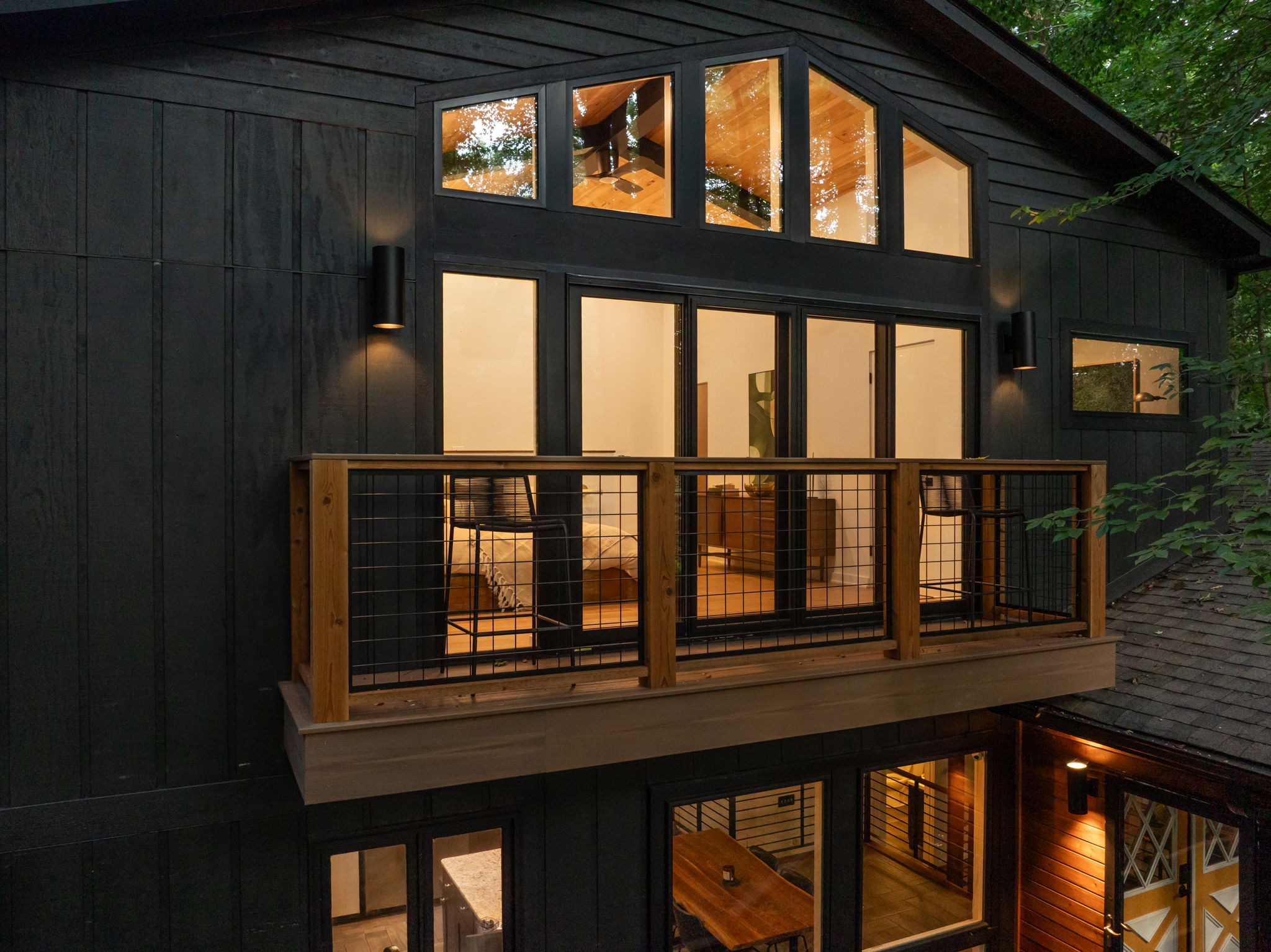 Exterior balcony with cable railing and large windows – Modern home addition by Emergent Construction blending indoor and outdoor living.