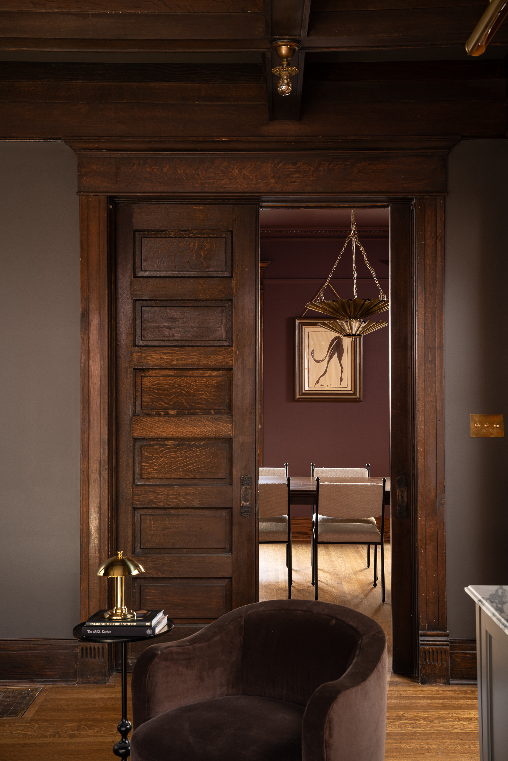 Victorian interior doorway featuring original stained wood trim, paneled doors, and detailed millwork.
