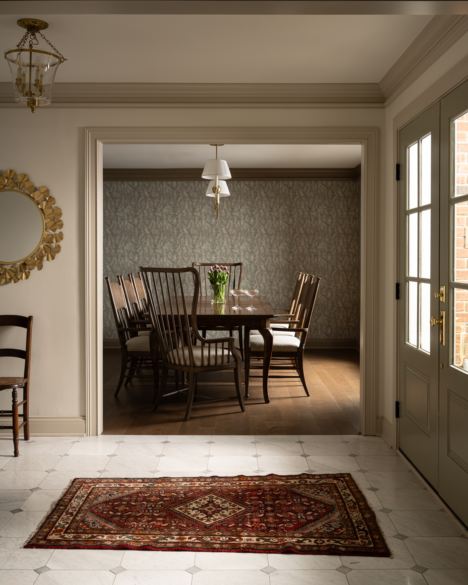 Renovated dining room with traditional wood furniture, large windows, and a decorative area rug.